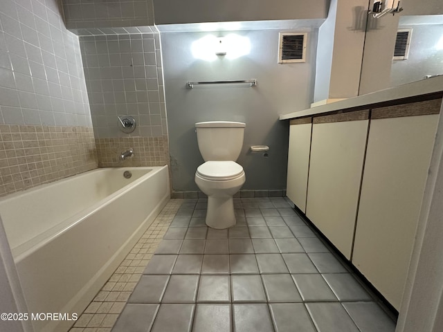 bathroom with tiled shower / bath, tile patterned floors, and toilet