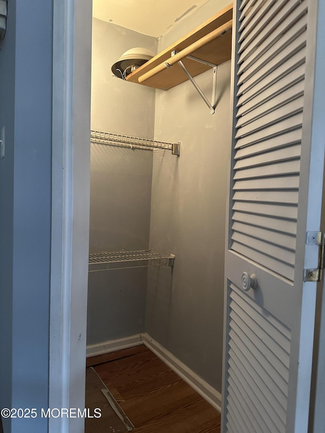 walk in closet with dark wood-type flooring