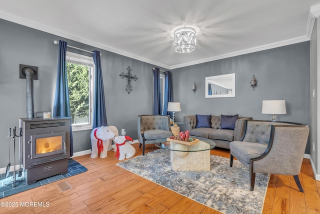 living room with hardwood / wood-style floors, a notable chandelier, a wood stove, and crown molding