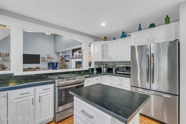 kitchen featuring white cabinets, decorative backsplash, and appliances with stainless steel finishes