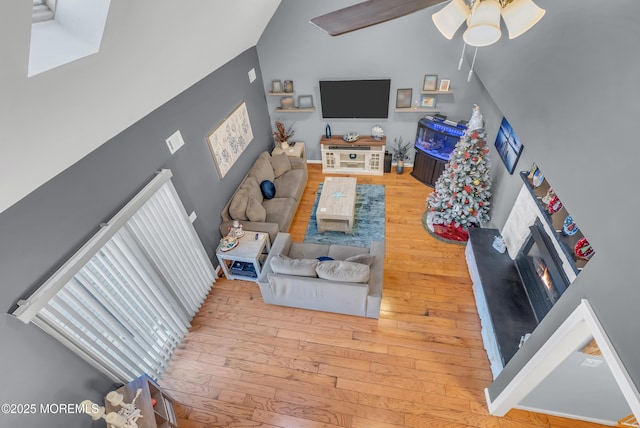 living room featuring hardwood / wood-style flooring, high vaulted ceiling, and ceiling fan