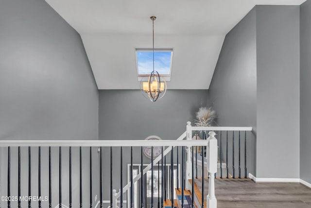 stairway with hardwood / wood-style floors, lofted ceiling, and a chandelier