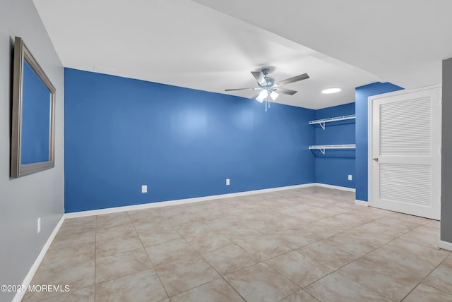 tiled empty room featuring ceiling fan