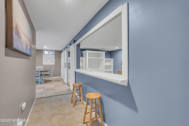 corridor featuring a barn door and light tile patterned flooring