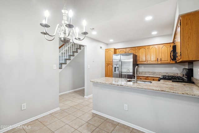 kitchen featuring stainless steel refrigerator with ice dispenser, stove, light tile patterned flooring, light stone counters, and sink