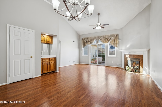 unfurnished living room with ceiling fan, hardwood / wood-style floors, high vaulted ceiling, and a tiled fireplace