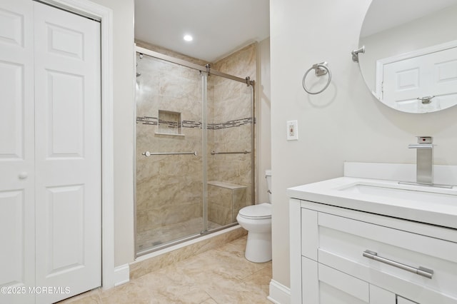 bathroom featuring toilet, tile patterned flooring, a shower with door, and vanity