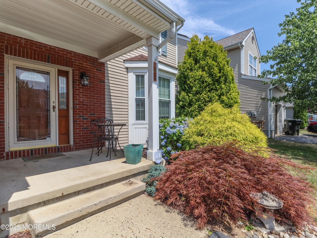 view of exterior entry featuring covered porch