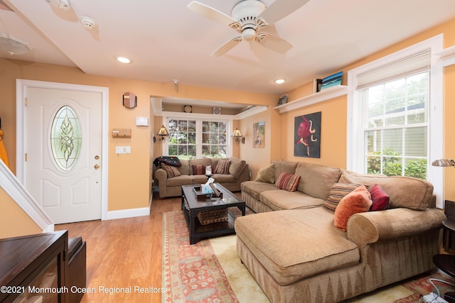 living room featuring ceiling fan, a healthy amount of sunlight, and light wood-type flooring