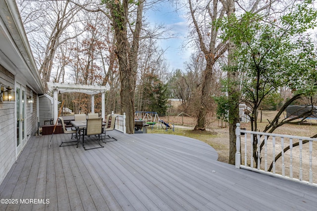 wooden deck with a playground and a pergola