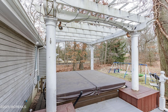 view of patio featuring a covered hot tub, a trampoline, a pergola, and a playground