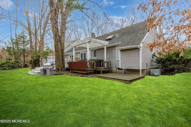 rear view of property featuring a jacuzzi, a patio area, a lawn, a pergola, and a deck