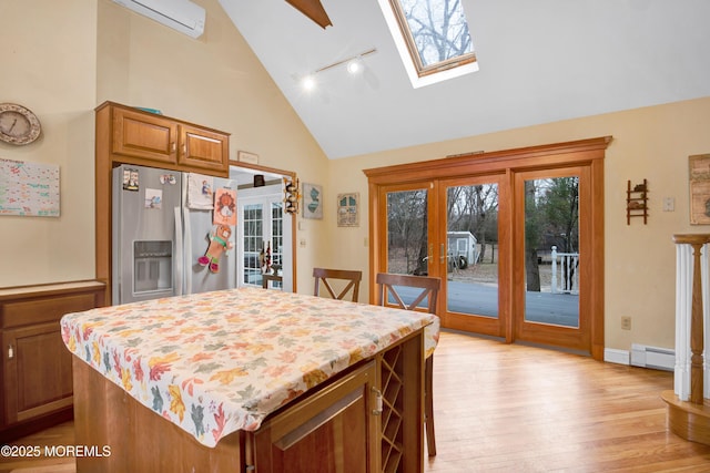 kitchen with a skylight, a center island, stainless steel fridge with ice dispenser, and french doors