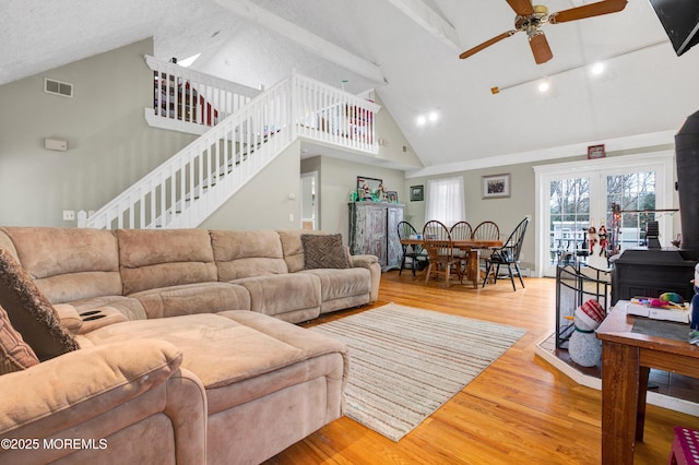 living room with hardwood / wood-style floors, ceiling fan, high vaulted ceiling, a textured ceiling, and beamed ceiling