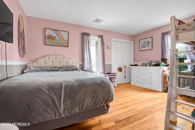 bedroom with light wood-type flooring and a closet