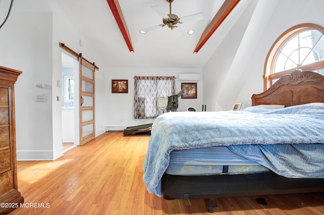 bedroom featuring a wall mounted AC, light hardwood / wood-style floors, a barn door, ceiling fan, and vaulted ceiling with beams