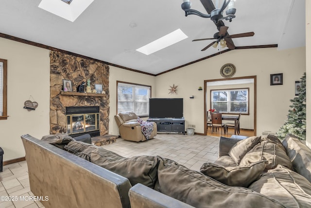 living room with a wealth of natural light, ceiling fan, a fireplace, and vaulted ceiling