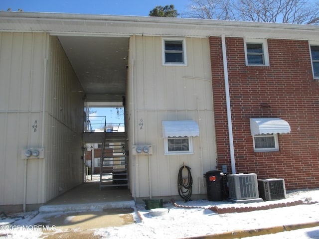 snow covered building with cooling unit