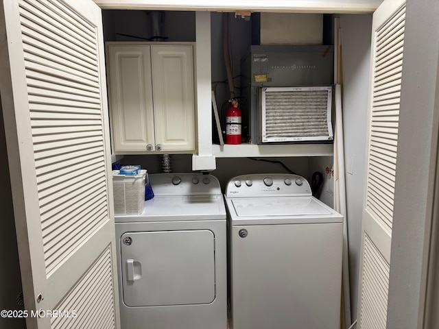 clothes washing area featuring cabinets and washing machine and dryer