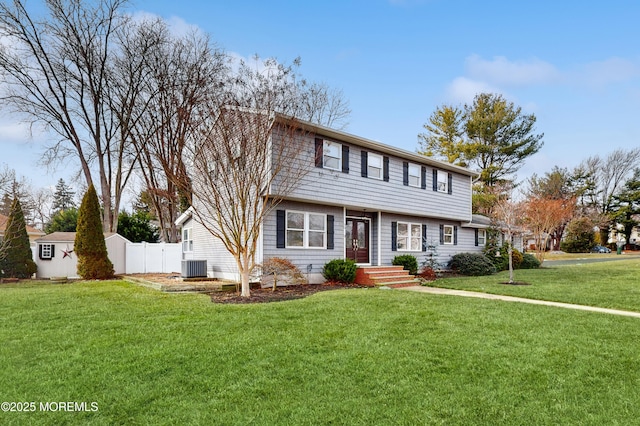 view of front of property featuring a front yard, central AC unit, and a storage shed