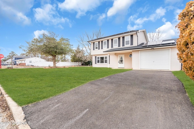 front of property with a garage, a front lawn, and solar panels