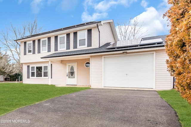 view of property featuring a garage, a front yard, and solar panels