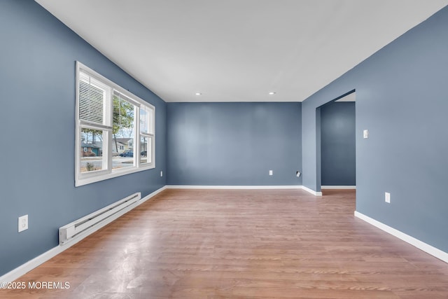 spare room with a baseboard radiator and light hardwood / wood-style flooring