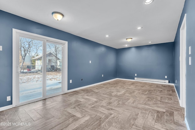 spare room with a baseboard heating unit and light parquet flooring