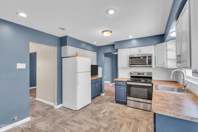 kitchen with appliances with stainless steel finishes, sink, and white cabinets