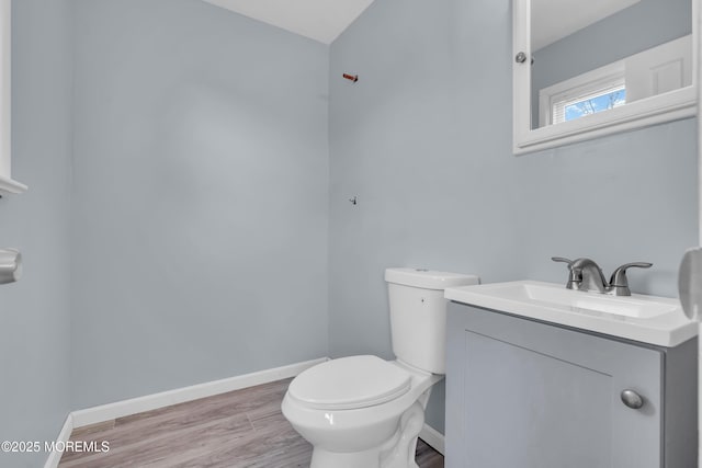 bathroom with hardwood / wood-style flooring, vanity, and toilet