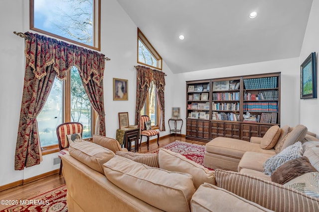 living room featuring high vaulted ceiling and light wood-type flooring