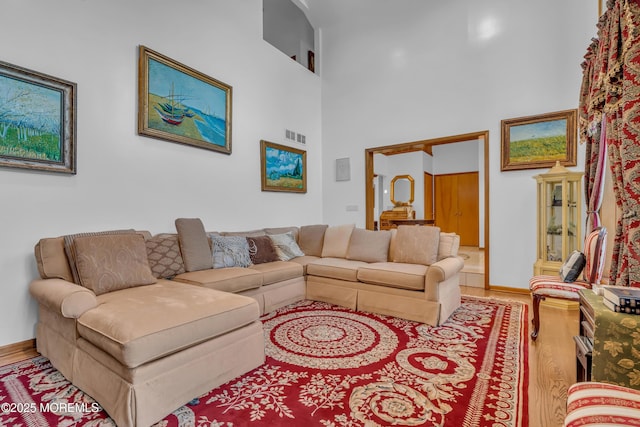 living room featuring a high ceiling and wood-type flooring