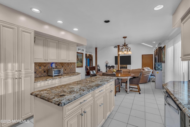 kitchen with light stone counters, dishwasher, hanging light fixtures, a kitchen island, and backsplash