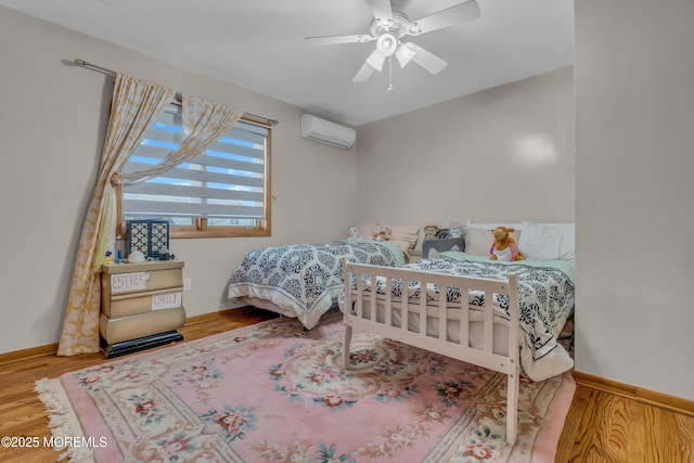 bedroom featuring ceiling fan, hardwood / wood-style flooring, and a wall mounted AC