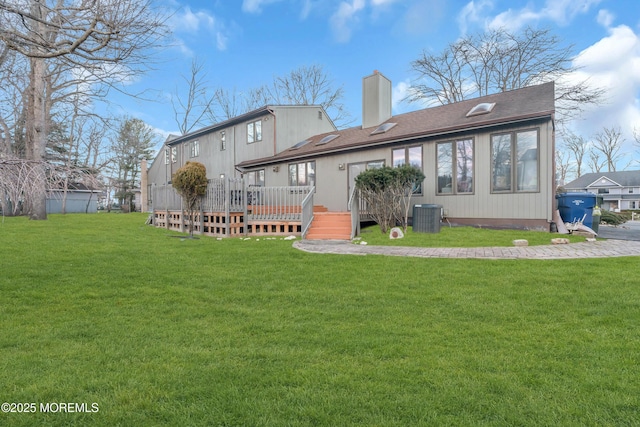 rear view of property featuring central AC, a yard, and a wooden deck