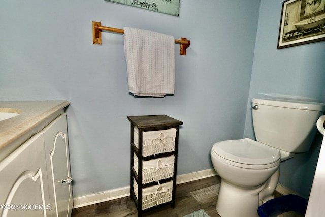 bathroom featuring vanity, wood-type flooring, and toilet