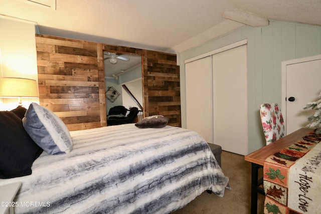 carpeted bedroom with wood walls and a closet