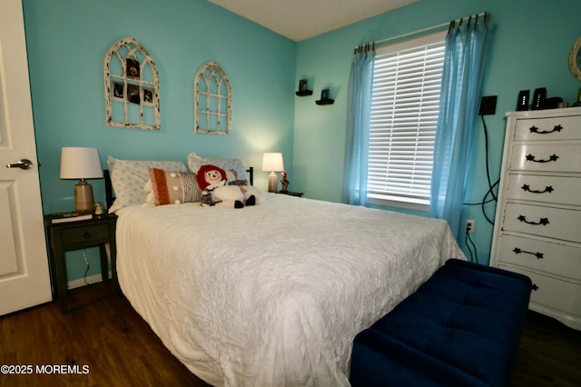 bedroom with dark hardwood / wood-style floors and multiple windows