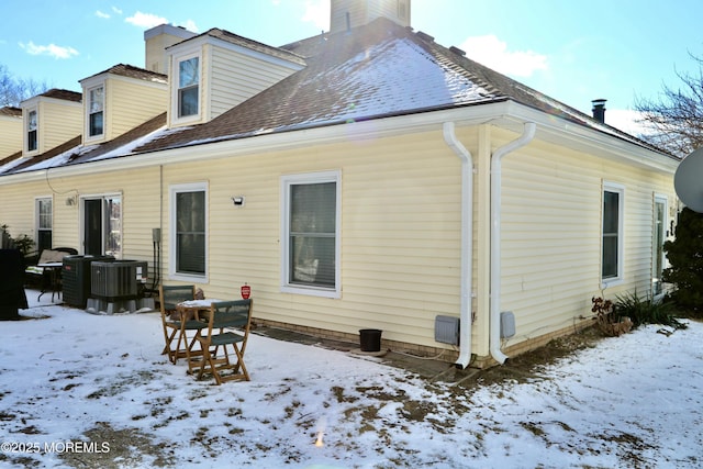 snow covered property with central AC unit