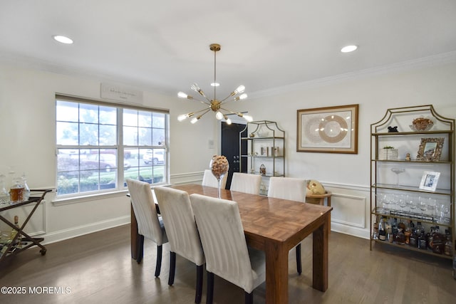 dining area featuring dark hardwood / wood-style floors, ornamental molding, and an inviting chandelier