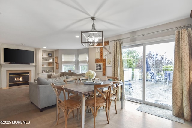 dining area featuring plenty of natural light, light hardwood / wood-style floors, and a chandelier