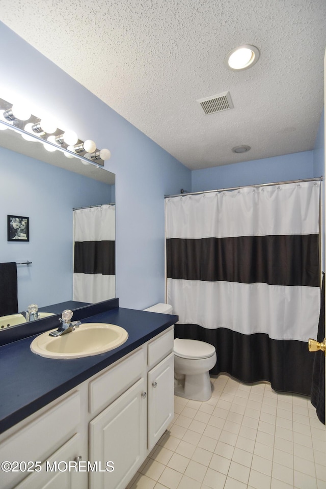 bathroom featuring walk in shower, tile patterned floors, a textured ceiling, toilet, and vanity