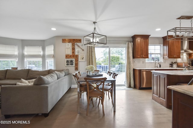 dining room with sink, light wood-type flooring, and a notable chandelier