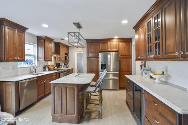 kitchen featuring a center island, backsplash, sink, hanging light fixtures, and stainless steel appliances