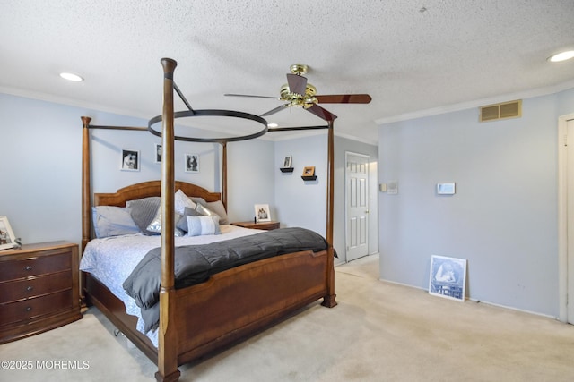 carpeted bedroom with a textured ceiling, ceiling fan, and crown molding