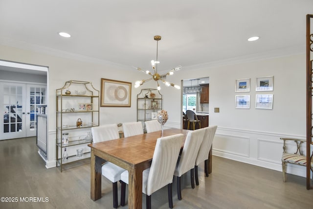 dining area featuring crown molding, french doors, a chandelier, and hardwood / wood-style flooring