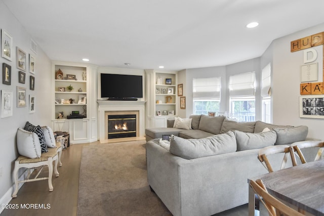 living room with wood-type flooring and built in features