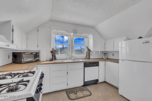 kitchen featuring a textured ceiling, white cabinetry, vaulted ceiling, and white appliances