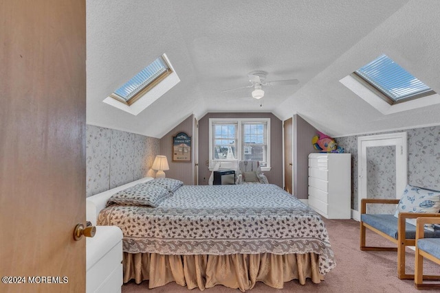 bedroom with vaulted ceiling, ceiling fan, carpet floors, and a textured ceiling