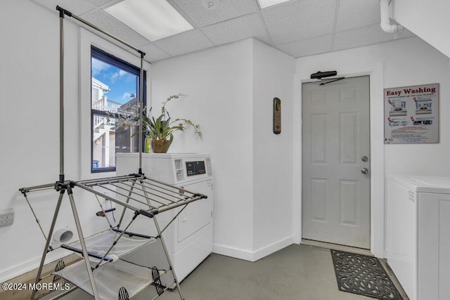 interior space with a paneled ceiling, washer and clothes dryer, and concrete floors